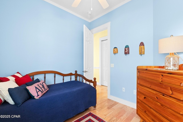 bedroom with baseboards, ornamental molding, a ceiling fan, and light wood-style floors