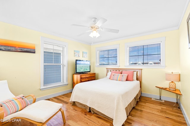 bedroom featuring light wood-type flooring, baseboards, multiple windows, and ornamental molding