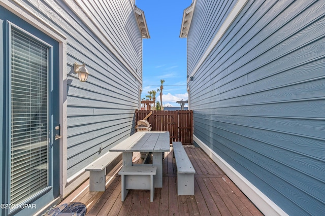 deck featuring outdoor dining space and fence