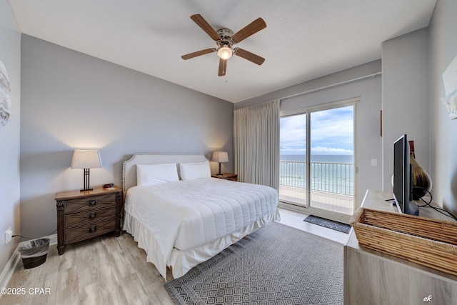 bedroom featuring access to exterior, light wood-style flooring, a ceiling fan, and baseboards