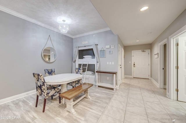 dining space featuring baseboards, a textured ceiling, a chandelier, and crown molding