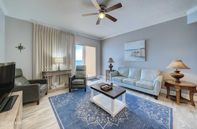 living area with crown molding, ceiling fan, baseboards, wood finished floors, and a textured ceiling