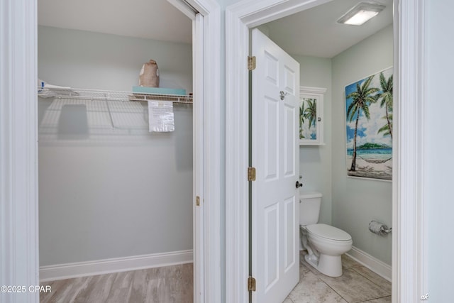 bathroom with baseboards and toilet