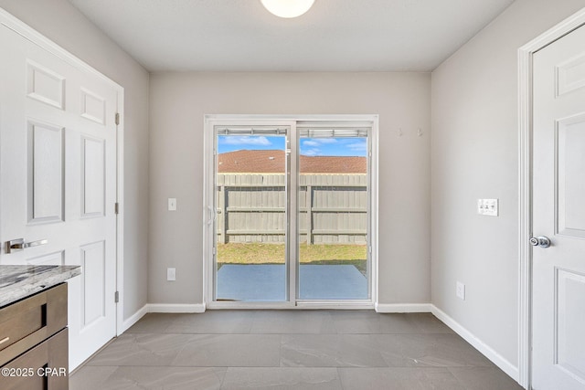 doorway to outside with baseboards