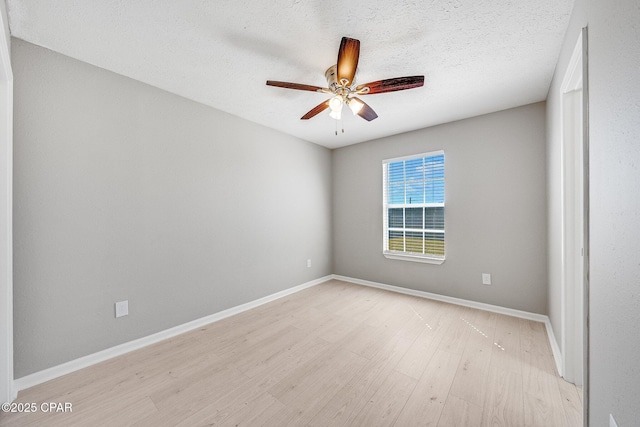 unfurnished room featuring ceiling fan, a textured ceiling, light wood-style flooring, and baseboards