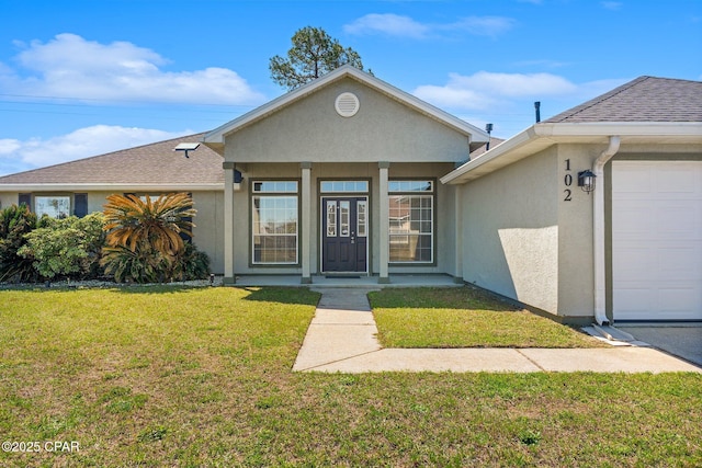 view of front facade with a garage, roof with shingles, a front yard, and stucco siding