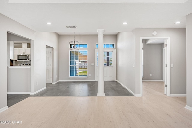 entrance foyer with baseboards, recessed lighting, wood finished floors, and ornate columns