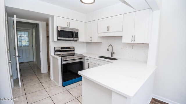 4305 Bay Point Rd Unit 459, Panama City, FL 32408 - kitchen featuring white cabinetry, light countertops, appliances with stainless steel finishes, and a sink