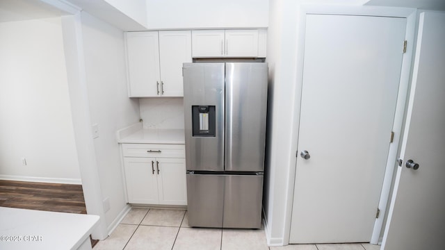 4305 Bay Point Rd Unit 459, Panama City, FL 32408 - kitchen with light tile patterned floors, stainless steel fridge, white cabinetry, baseboards, and light countertops