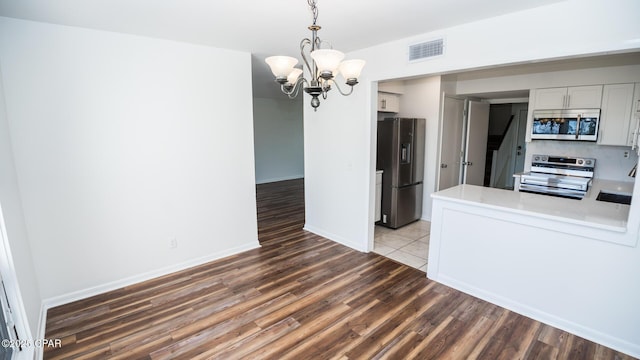 4305 Bay Point Rd Unit 459, Panama City, FL 32408 - kitchen with wood finished floors, a notable chandelier, visible vents, light countertops, and appliances with stainless steel finishes