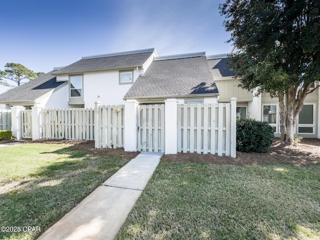 4305 Bay Point Rd Unit 459, Panama City, FL 32408 - view of front of property featuring fence private yard, a shingled roof, a front lawn, and stucco siding