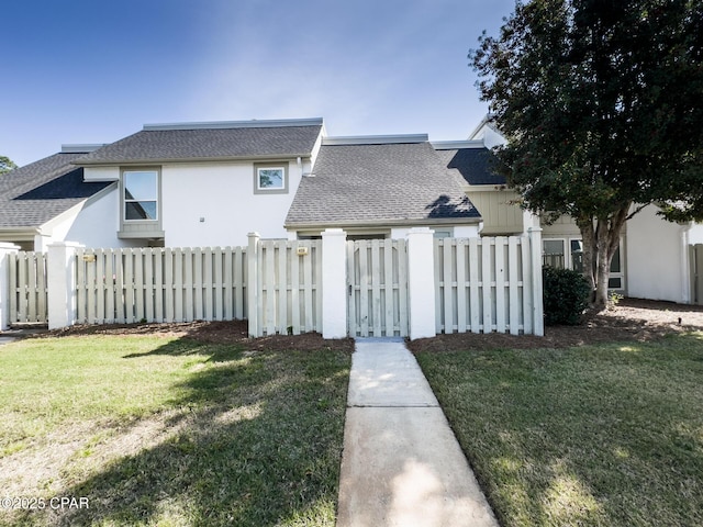 4305 Bay Point Rd Unit 459, Panama City, FL 32408 - view of front of property with a shingled roof, a fenced front yard, stucco siding, and a front lawn