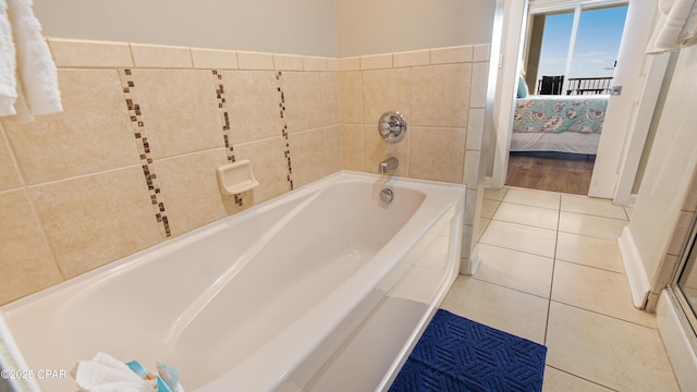 bathroom featuring tile walls, ensuite bath, a bath, and tile patterned floors