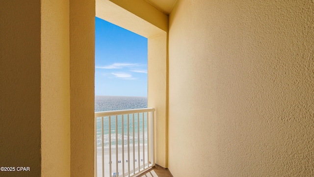 balcony featuring a water view and a beach view