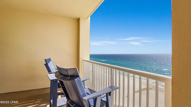 balcony featuring a water view and a beach view