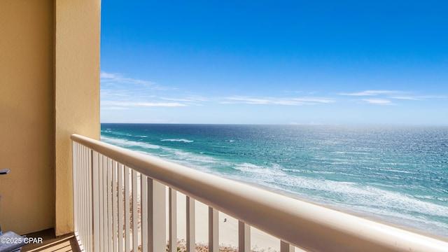 balcony with a water view and a view of the beach