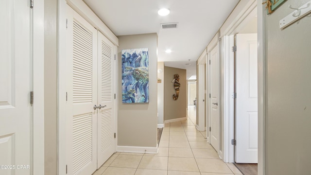 hallway with recessed lighting, visible vents, baseboards, and light tile patterned floors