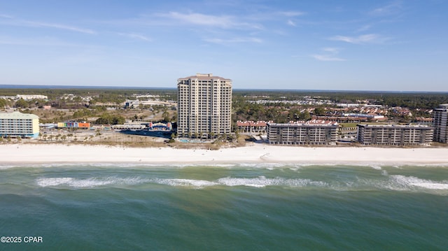 drone / aerial view featuring a water view, a beach view, and a city view