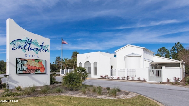 view of front facade featuring fence and stucco siding