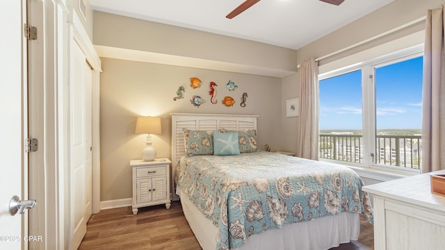 bedroom with ceiling fan, baseboards, wood finished floors, and access to exterior