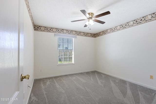 carpeted empty room featuring ceiling fan, a textured ceiling, and baseboards