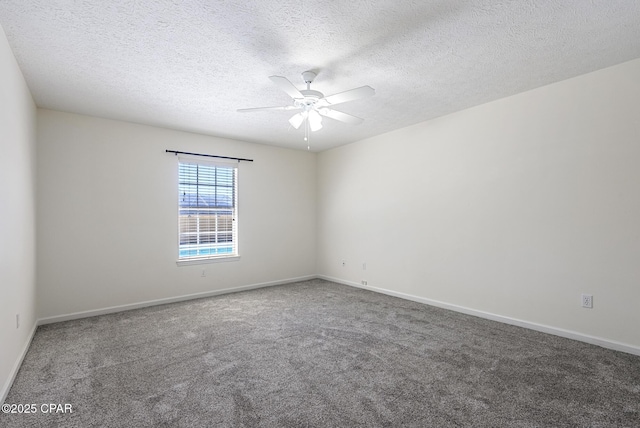 carpeted spare room featuring a textured ceiling, baseboards, and a ceiling fan