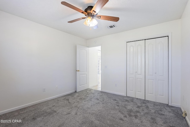 unfurnished bedroom with carpet floors, baseboards, visible vents, and a closet