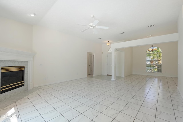 unfurnished living room featuring ceiling fan with notable chandelier, visible vents, and a high end fireplace