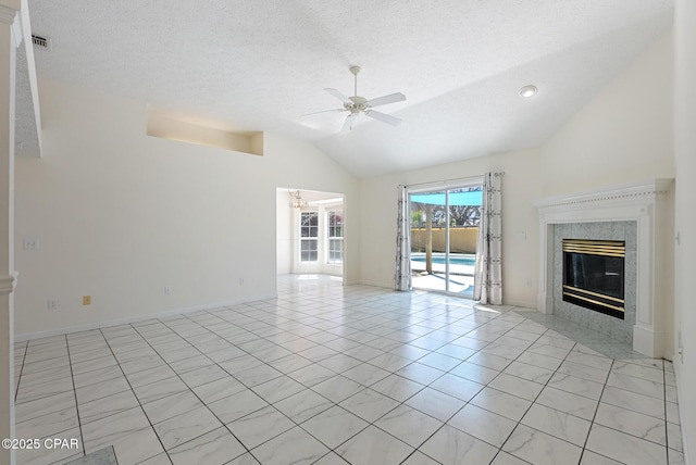 unfurnished living room featuring lofted ceiling, visible vents, a premium fireplace, a ceiling fan, and a textured ceiling