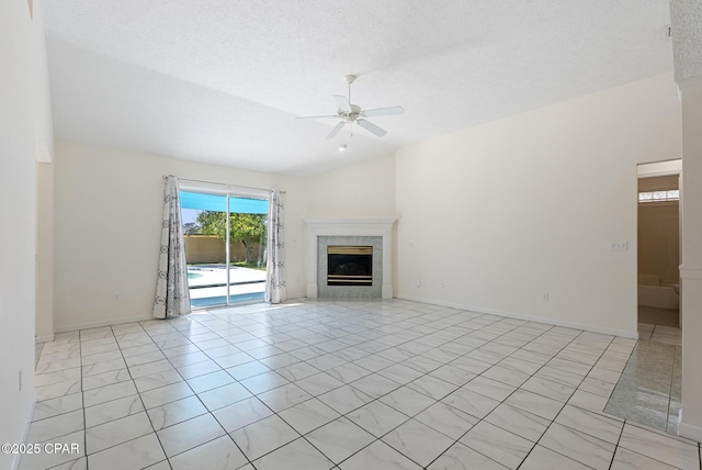 unfurnished living room with a textured ceiling, a fireplace, a ceiling fan, baseboards, and vaulted ceiling