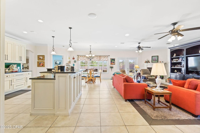 living area with ceiling fan with notable chandelier, crown molding, light tile patterned floors, and recessed lighting