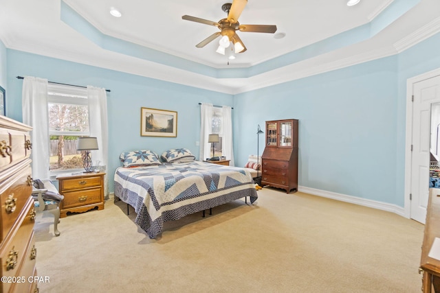 bedroom featuring light colored carpet, baseboards, crown molding, and a tray ceiling