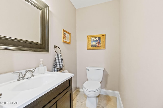 half bathroom with tile patterned floors, toilet, vanity, and baseboards