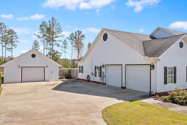 view of property exterior featuring a garage, roof with shingles, and fence