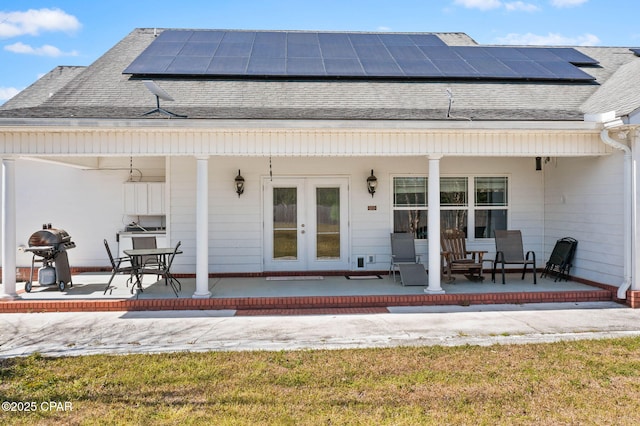 back of property featuring a porch, french doors, and roof with shingles