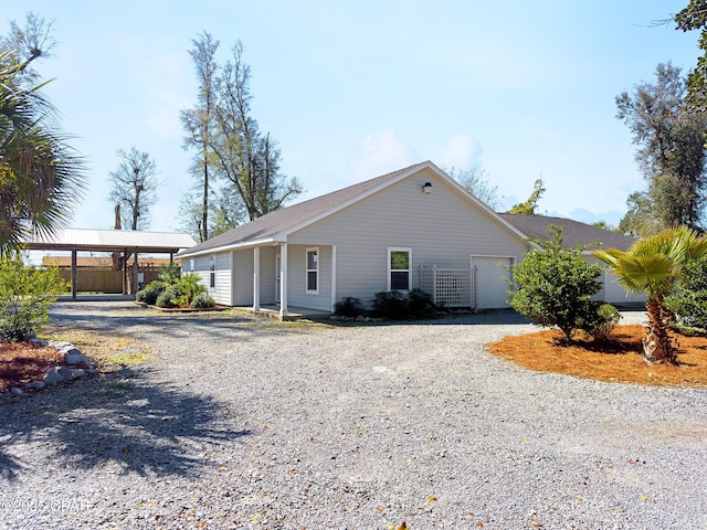 ranch-style home with gravel driveway and an attached garage