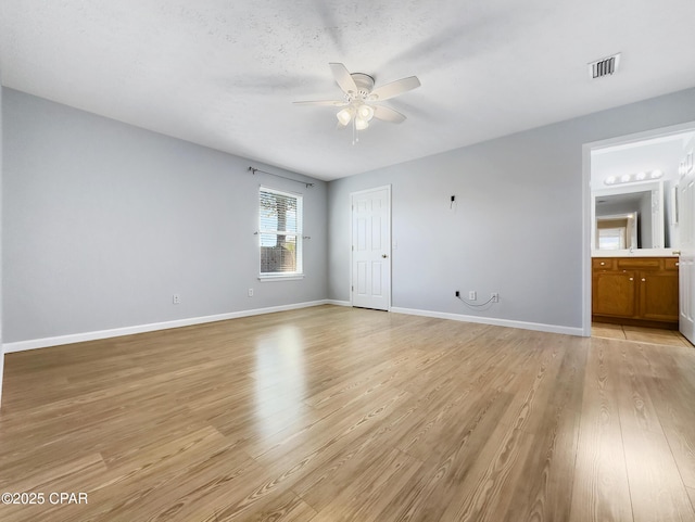 unfurnished bedroom featuring visible vents, light wood-style flooring, connected bathroom, and baseboards