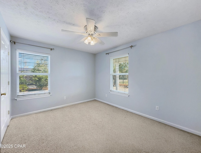 carpeted spare room with ceiling fan, a textured ceiling, and baseboards