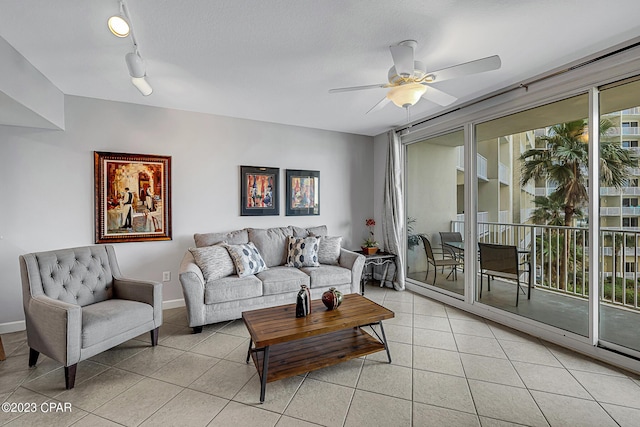 living room with light tile patterned floors, ceiling fan, track lighting, and baseboards