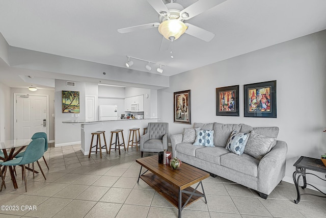 living room with baseboards, visible vents, a ceiling fan, and light tile patterned flooring