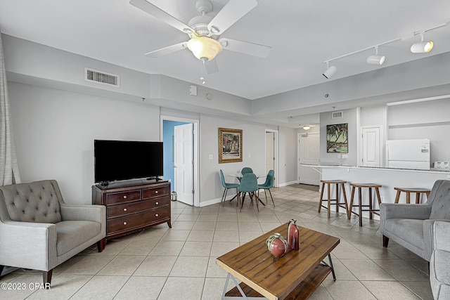 living room featuring light tile patterned floors, visible vents, and a ceiling fan