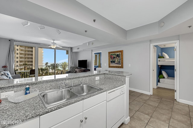 kitchen with a sink, white cabinets, open floor plan, and dishwasher