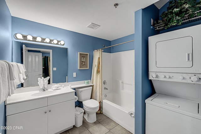 bathroom with stacked washer and dryer, visible vents, toilet, vanity, and tile patterned floors