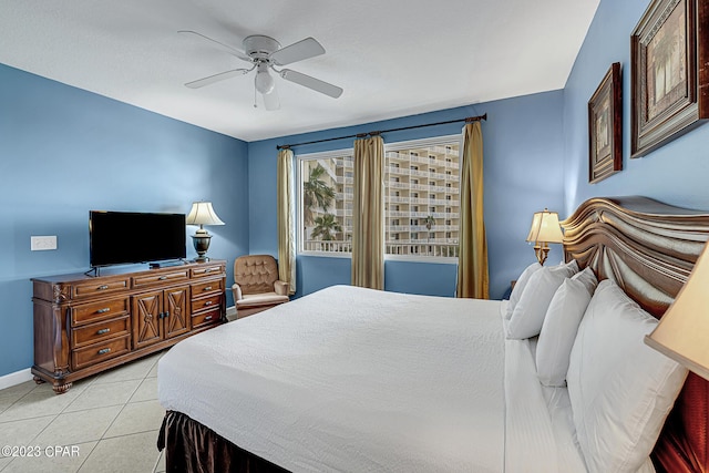 bedroom featuring a ceiling fan, baseboards, and light tile patterned floors