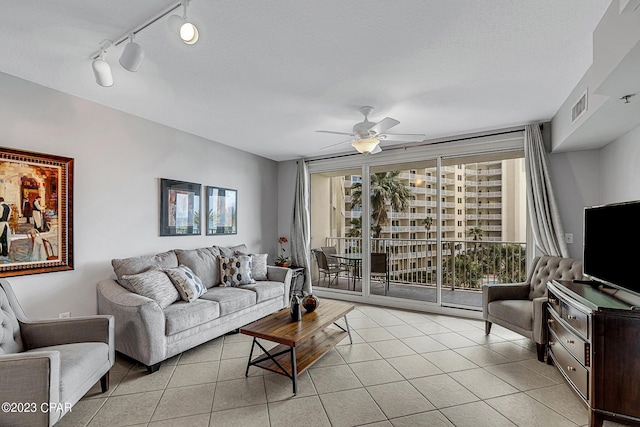 living room with expansive windows, visible vents, ceiling fan, and light tile patterned floors