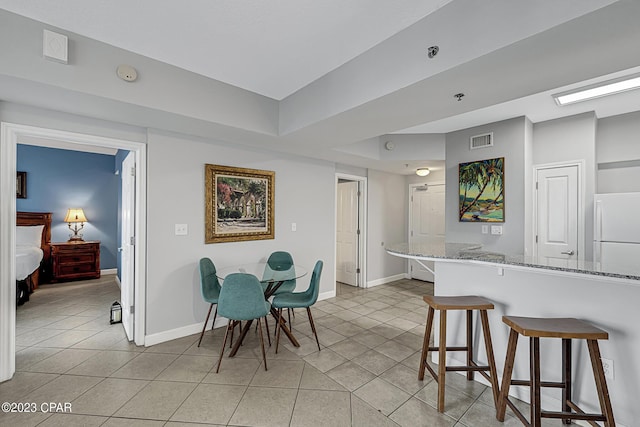 dining room with light tile patterned floors, baseboards, and visible vents