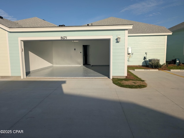 garage featuring central AC and concrete driveway