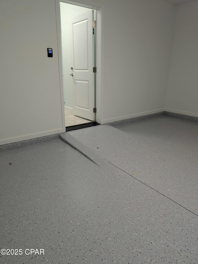 spare room featuring baseboards and speckled floor