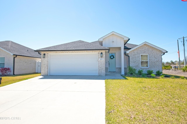 view of front of house featuring a front yard, an attached garage, brick siding, and concrete driveway