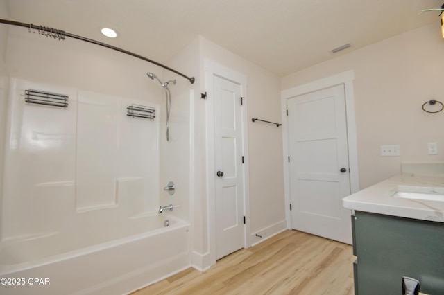 bathroom with visible vents, vanity, shower / bathtub combination, and wood finished floors